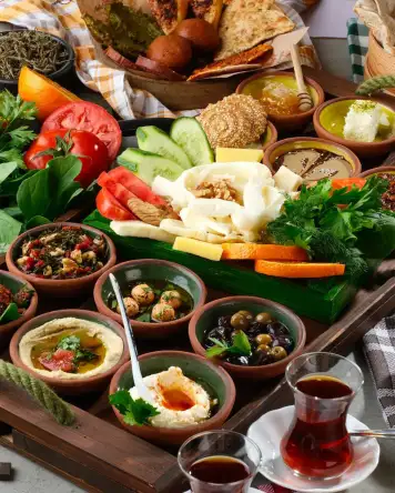 Antakya kahvaltısı, zengin meze çeşitleri, peynirler, zeytinler, bal ve geleneksel lezzetlerle hazırlanmış kahvaltı sofrası