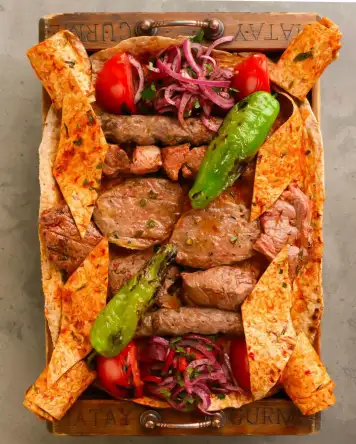 Karışık kebap tabağı, şiş kebap, kuşbaşı et, ızgara sebzeler ve lavaş ile servis edilen Hatay usulü zengin kebap sunumu